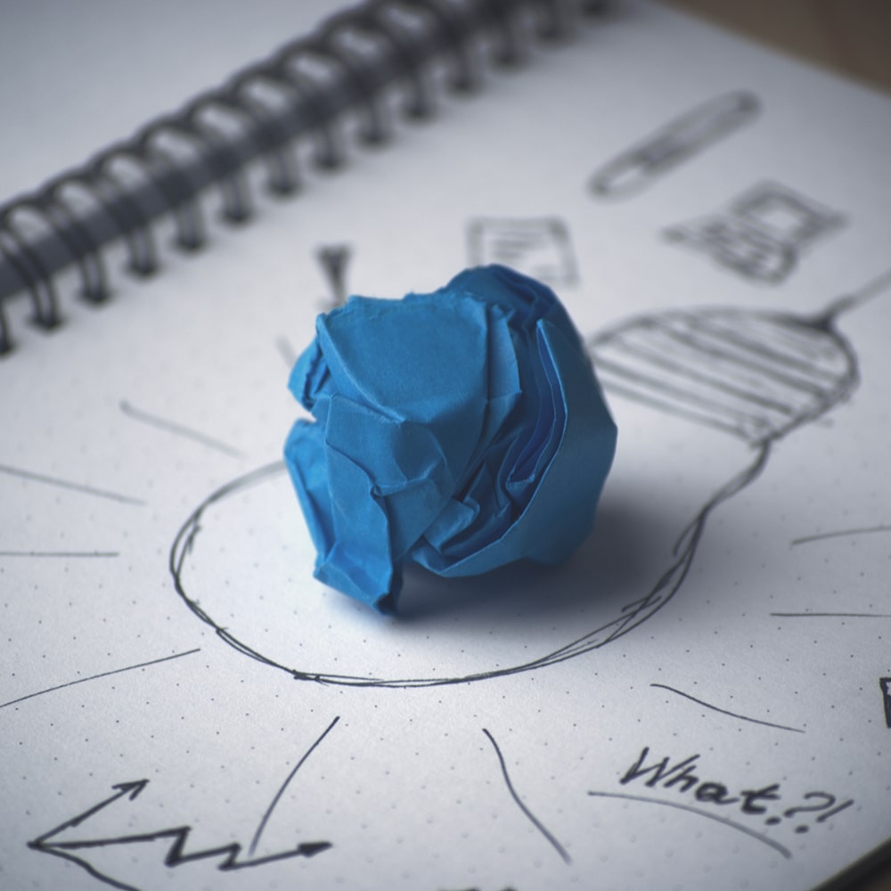 Blue paper ball on a white piece of paper.